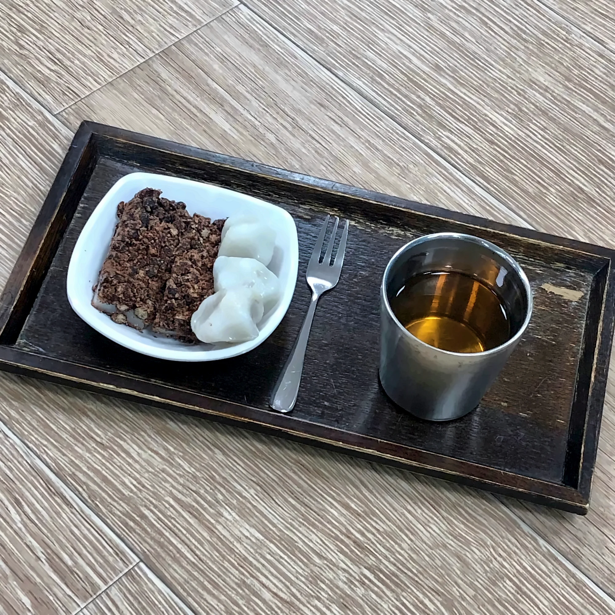 검은 쟁반 위 접시에 담은 떡 두 가지와 차 한 잔