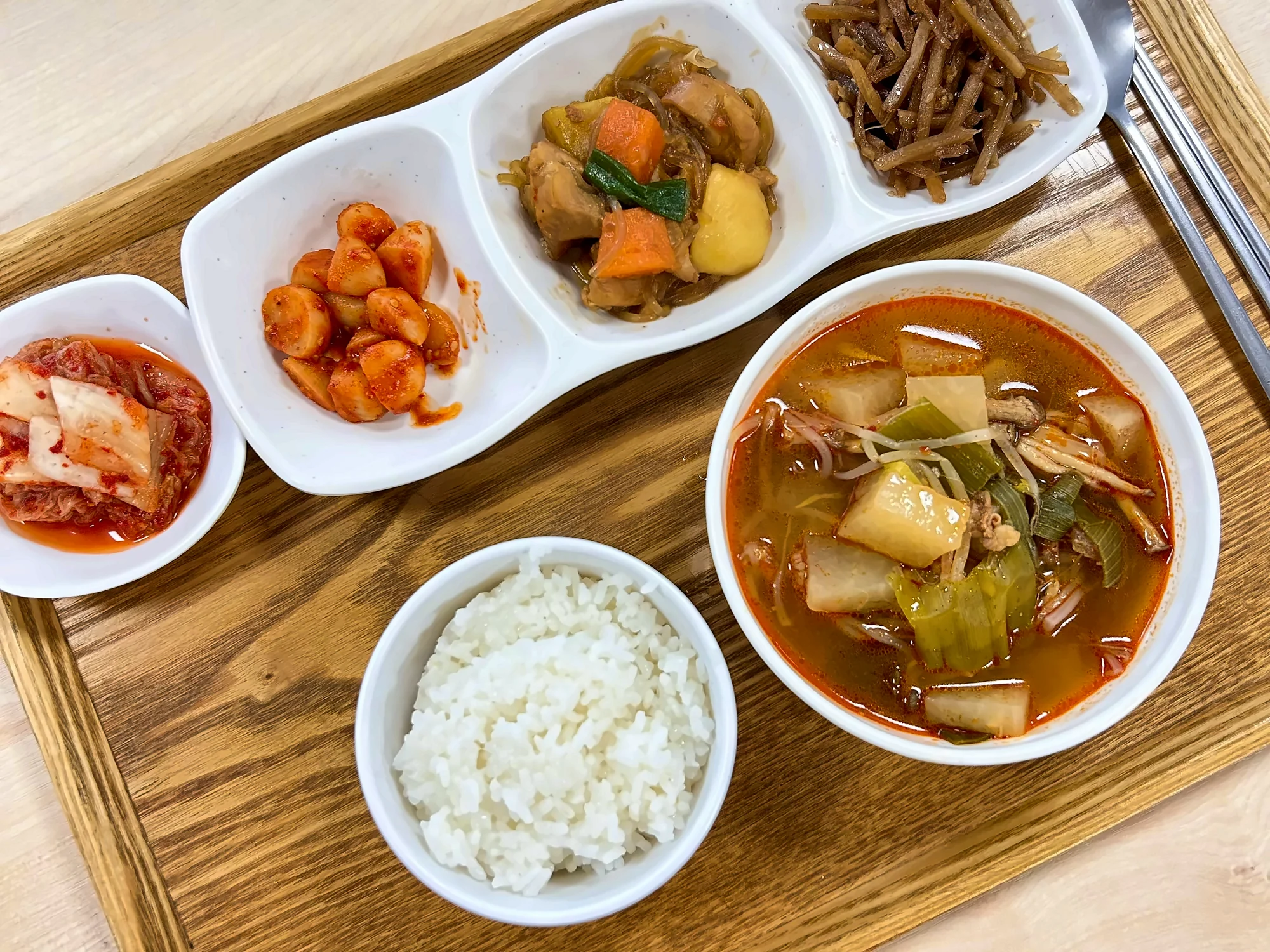 나무 쟁반에 차린 점심. 흰밥과 얼큰한 국, 고기찜·우엉조림 등 반찬 네 가지