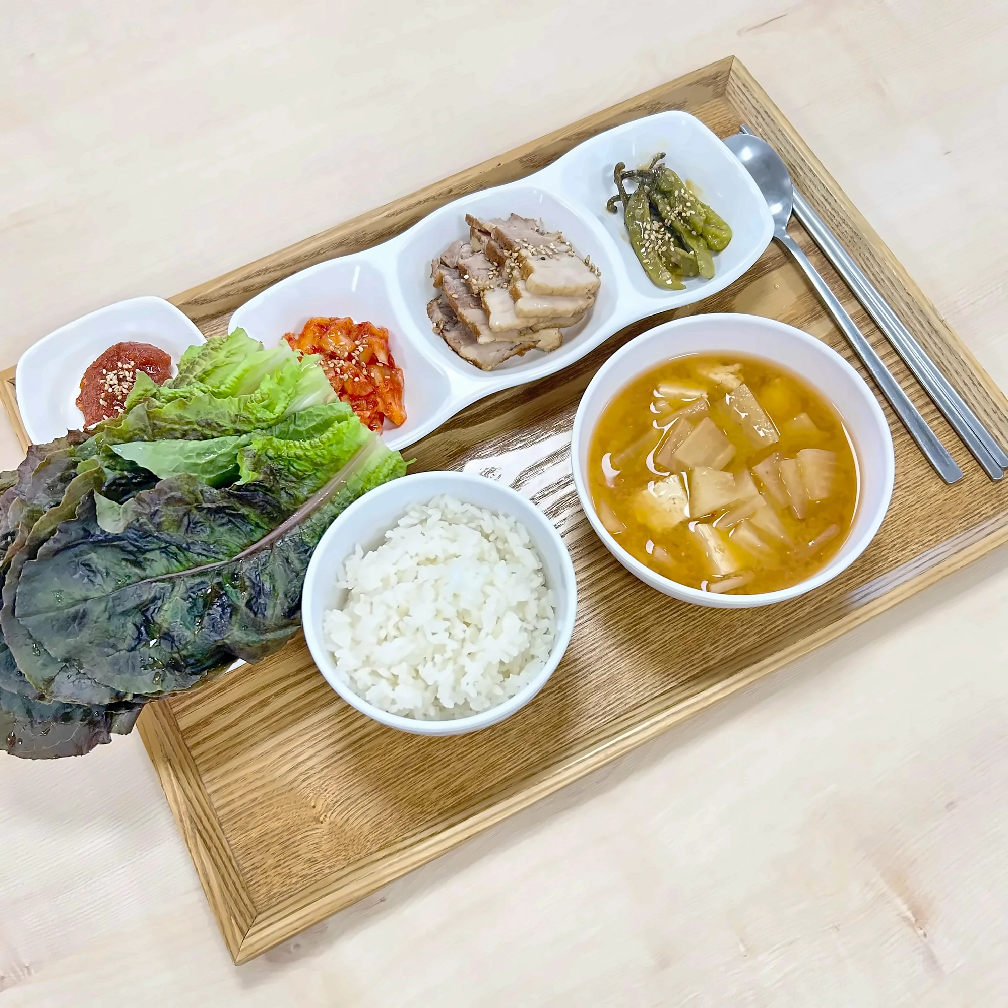나무 쟁반에 차린 점심. 돼지고기 수육과 꽈리고추, 상추 쌈, 된장찌개