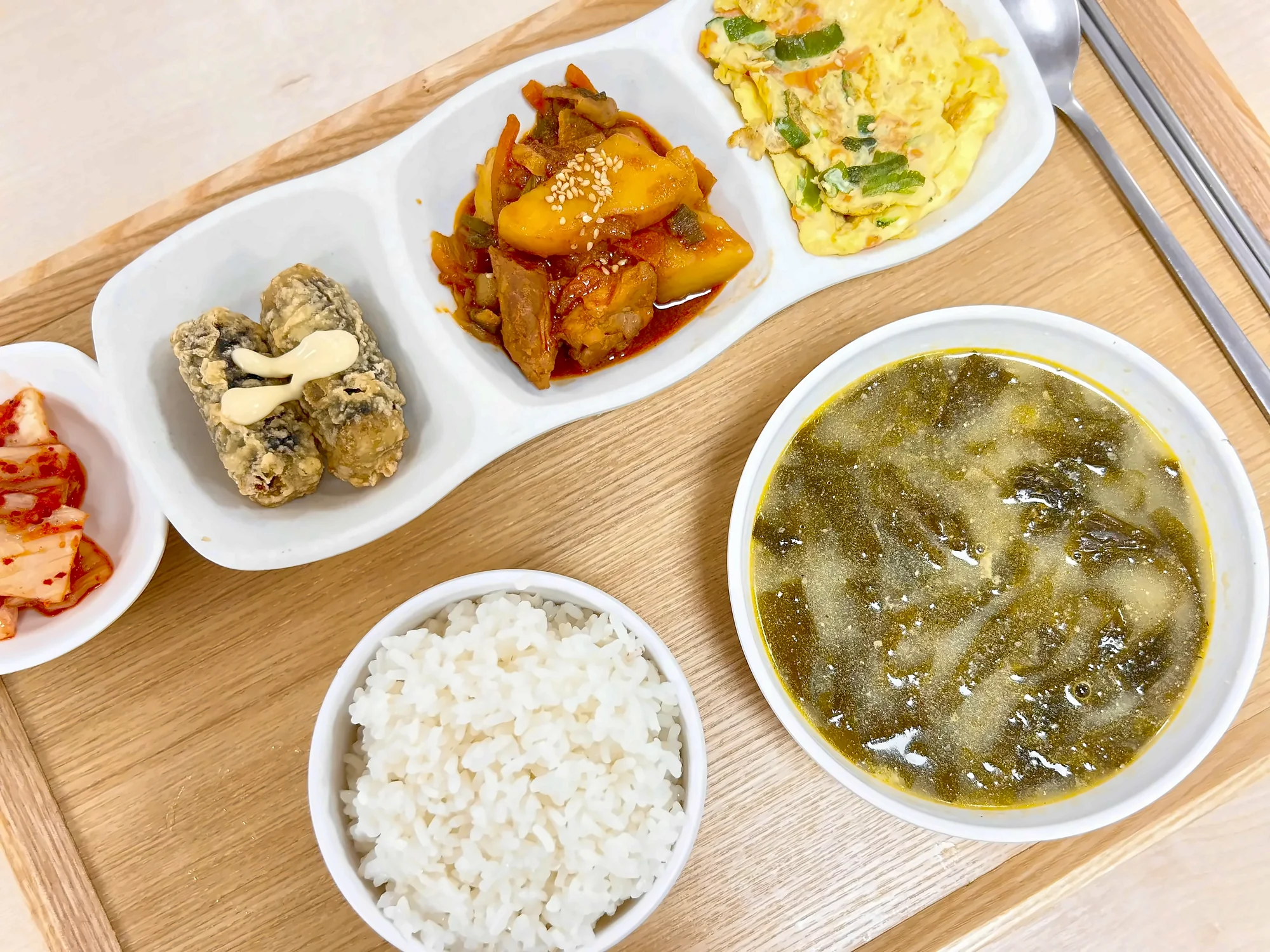 나무 쟁반에 차린 점심. 흰밥과 미역국, 계란말이를 포함한 반찬 네 가지